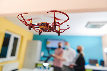 Image showing A group of students working together in a laboratory, dedicated to exploring the aerodynamic capabilities of a drone