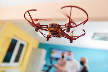 Image showing A group of students working together in a laboratory, dedicated to exploring the aerodynamic capabilities of a drone