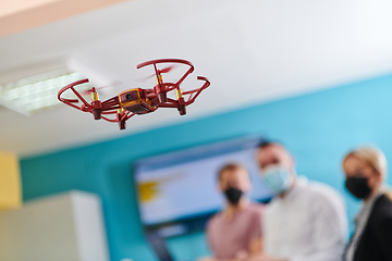 Image showing A group of students working together in a laboratory, dedicated to exploring the aerodynamic capabilities of a drone