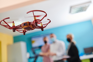 Image showing A group of students working together in a laboratory, dedicated to exploring the aerodynamic capabilities of a drone