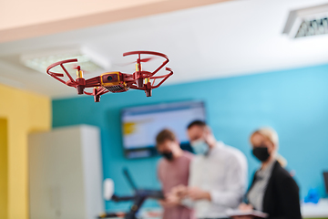 Image showing A group of students working together in a laboratory, dedicated to exploring the aerodynamic capabilities of a drone