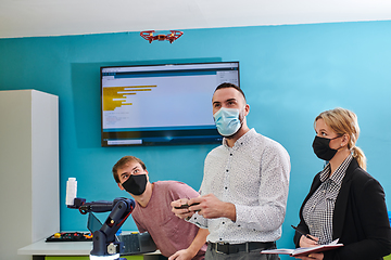 Image showing A group of students working together in a laboratory, dedicated to exploring the aerodynamic capabilities of a drone