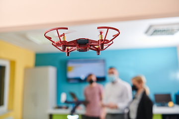 Image showing A group of students working together in a laboratory, dedicated to exploring the aerodynamic capabilities of a drone