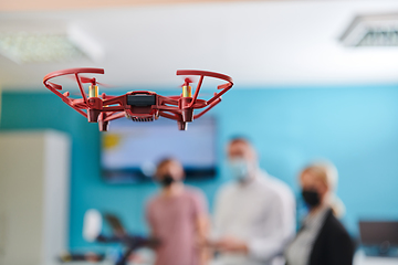 Image showing A group of students working together in a laboratory, dedicated to exploring the aerodynamic capabilities of a drone