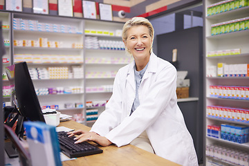 Image showing Pharmacy, smile and portrait of woman pharmacist at counter in drugstore, happy customer service and advice in medicine. Prescription drugs, senior employee typing at checkout with pills and medicine