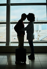 Image showing Silhouette, travel and love with couple in airport and hug for departure, flight and say goodbye. Shadow, holiday and sad man and woman leave in embrace by window for journey, international