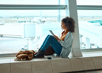 Image showing Airport, travel and black woman with tablet by window waiting for global flight, departure and transport. International plane, lobby and girl with digital tech for internet, schedule and social media