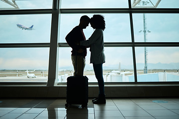 Image showing Airport, couple and silhouette of love, hug and leaving on vacation on a airplane flight. Plane departure, holiday and young people shadow by a window for journey, vacation break or immigration