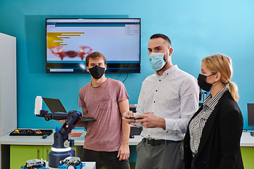 Image showing A group of students working together in a laboratory, dedicated to exploring the aerodynamic capabilities of a drone