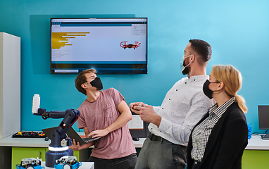 Image showing A group of students working together in a laboratory, dedicated to exploring the aerodynamic capabilities of a drone