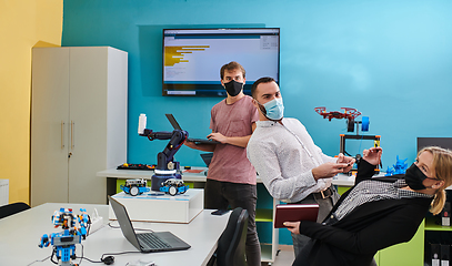 Image showing A group of students working together in a laboratory, dedicated to exploring the aerodynamic capabilities of a drone