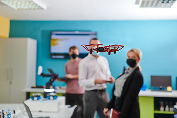 Image showing A group of students working together in a laboratory, dedicated to exploring the aerodynamic capabilities of a drone