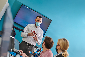 Image showing A group of students working together in a laboratory, dedicated to exploring the aerodynamic capabilities of a drone