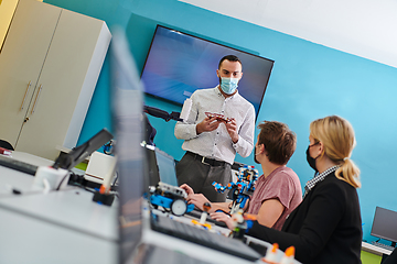 Image showing A group of students working together in a laboratory, dedicated to exploring the aerodynamic capabilities of a drone