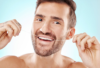 Image showing Floss, teeth and portrait of man isolated on blue background for mouth cleaning, smile or beauty health. Mature model or dental person with product in tooth, gum and dentist healthcare in studio
