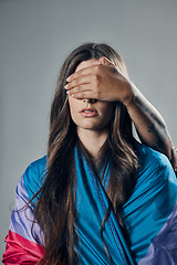 Image showing Surprise, cover and woman with bisexual flag isolated on a grey studio background. Love, freedom and girl in support of LGBT community with person covering eyes to be surprised for pride on backdrop