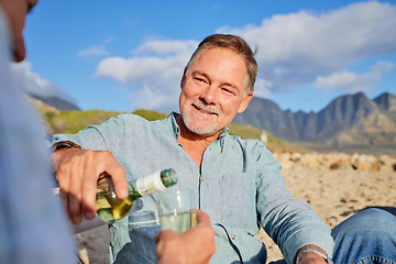 Image showing Love, wine and happy with old couple on beach for celebration, anniversary and romantic date. Smile, relax and sunset with man pouring champagne for woman for vacation, summer break or travel holiday