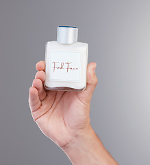 Image showing Skincare, hand with bottle of cream for face and mock up isolated on grey background with space for product placement. Luxury spa facial lotion, dermatology and cosmetics in advertising and marketing