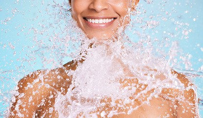 Image showing Water, splash and black woman cleaning her body for beauty, skincare and self care isolated in studio blue background. Portrait, model and young female washing skin for hygiene, aqua and hydration