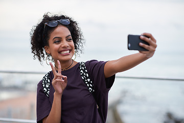 Image showing Selfie, peace sign and smile of black woman in city taking pictures for happy memory. Travel, street and female with v hand gesture, having fun and enjoying time while taking photo for social media.