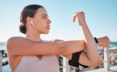 Image showing Beach fitness, music and woman stretching for cardio exercise running, marathon training and listening to radio podcast. Nature freedom, calm peace and athlete warm up for outdoor performance workout