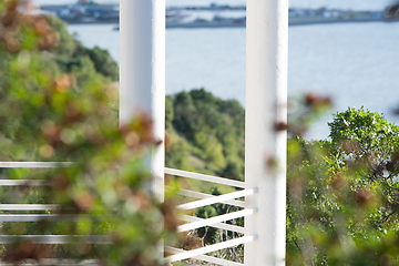 Image showing White columns of the gazebo against the backdrop of forest and sea