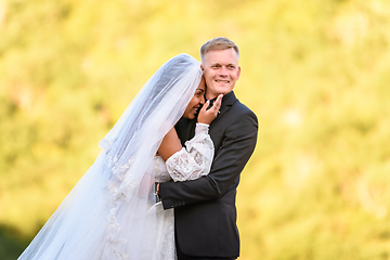 Image showing Happy newlyweds against the backdrop of sunny evening foliage, the girl laughs and buries herself in her husband