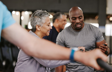 Image showing Senior group, exercise bike and personal trainer for fitness, time and retirement wellness by blurred background. Elderly woman, bicycle training or diversity with black man, stopwatch and motivation