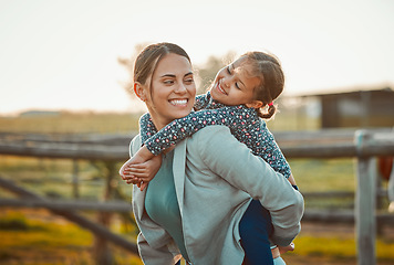 Image showing Mother, young girl and hug of a kid piggy back fun and parent care outdoor in equestrian field. Mom smile, child happiness and family in nature with blurred background in summer on holiday in a park