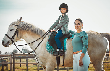 Image showing .Portrait of woman standing, child on horse and ranch lifestyle with smile and equestrian sports on field. Countryside, rural nature and farm animals, mother teaching girl to ride stallion in USA.