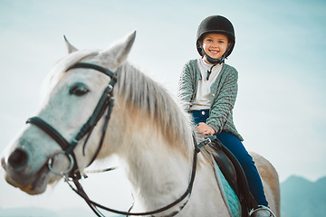 Image showing Ranch, happy and girl child on a horse to practice riding for a championship, competition or race. Happiness, animal and kid with smile practicing to ride a pony pet on a field or farm in countryside