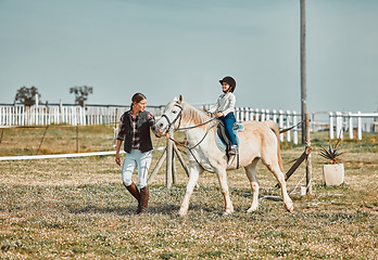 Image showing .Lesson, help and woman with a child on a horse for learning, sports and hobby on a farm in Italy. Helping, support and coach teaching a girl horseback riding for a physical activity in countryside.