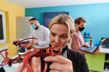 Image showing A group of students working together in a laboratory, dedicated to exploring the aerodynamic capabilities of a drone