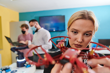 Image showing A group of students working together in a laboratory, dedicated to exploring the aerodynamic capabilities of a drone