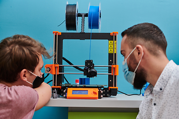 Image showing A group of colleagues collaborate in a lab while testing a 3D printer, demonstrating their commitment to technological advancement and scientific research.