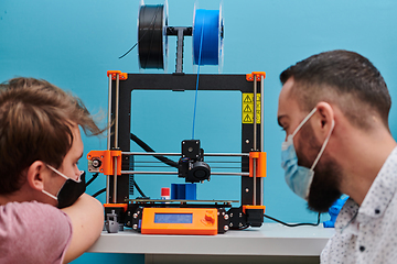 Image showing A group of colleagues collaborate in a lab while testing a 3D printer, demonstrating their commitment to technological advancement and scientific research.