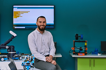 Image showing A bearded man in a modern robotics laboratory, immersed in research and surrounded by advanced technology and equipment.