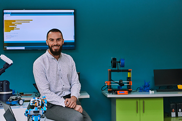 Image showing A bearded man in a modern robotics laboratory, immersed in research and surrounded by advanced technology and equipment.