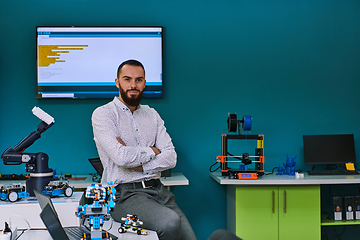 Image showing A bearded man in a modern robotics laboratory, immersed in research and surrounded by advanced technology and equipment.