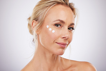 Image showing Portrait, skincare and face cream for mature woman in studio for wellness, hydration and care on grey background. facial, product or sunscreen for lady relax in luxury, cosmetic and moisture isolated