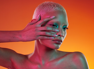 Image showing Neon, cosmetics and beauty, woman with hand in face, makeup and light in creative advertising on orange background. Cyberpunk, art and model isolated in skincare and futuristic mockup space in studio