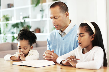 Image showing Family, worship and bible with father and kids praying at table for peace, religion and faith in their home. God, pray and children with parent for prayer, bible study or Jesus Christ praise together