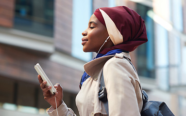 Image showing Happy, music and phone with black woman in city for relax, streaming and social media. Independent, internet and hijab radio with muslim girl listening to earphones for podcast, online and digital