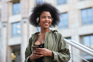 Image showing Music, phone and gen z black woman with headphones in city to relax and smile outside in street. Urban fashion, enjoying online streaming radio service and trendy girl listening to audio on earphones