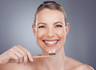 Image showing Bamboo toothbrush, toothpaste and portrait of woman for dental wellness, healthy cleaning or face cosmetics. Happy female teeth, eco wooden brush and mouth of smile, mature model or studio background