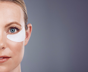 Image showing Skincare mask, eyes and portrait of woman on gray background for wellness, cosmetics and facial care. Salon mockup space, dermatology and half face with pads for anti aging, makeup and beauty product