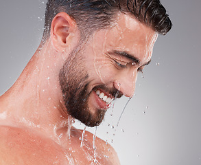 Image showing Shower, grooming and smile, man isolated on grey background for skincare, health and wellness mockup in studio. Water, face and happiness, male model cleaning and washing skin and facial hair profile