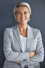 Image showing Smile, confidence and portrait of mature businesswoman with arms crossed isolated on blue background. Success, vision and leadership, happy senior woman in corporate management standing in studio.