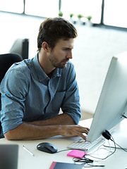 Image showing Concentrating, computer and typing with business man in office for web design, analytics and planning. Vision, technology and internet with employee in digital agency for idea, advertising and email