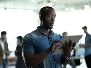 Image showing Technology, internet and black man with tablet reading email, sales or social media on web. Research, leadership and company ceo networking with online communication in management at startup office.